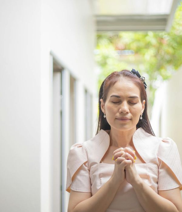 Person meditating peacefully outdoors with nature in the background.